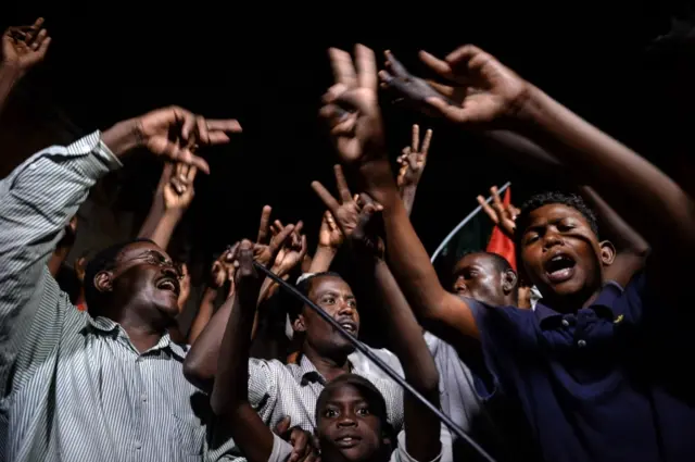 Sudanese protesters flash victory signs as they gather for a sit-in outside the military headquarters in Khartoum on May 19, 2019