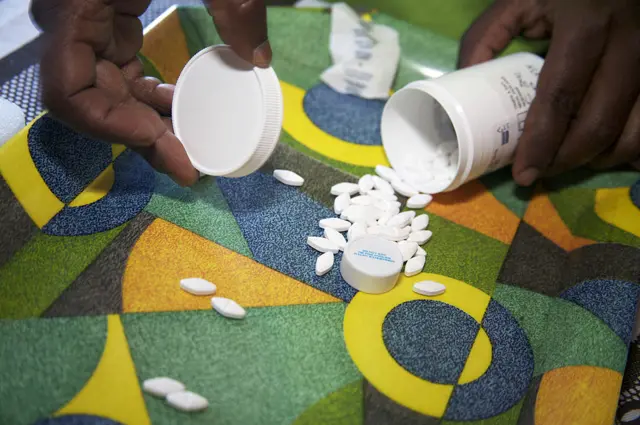 Caroline Futshane, a village health worker for the Keiskamma Trust, checking the antiretroviral drugs for a patient. Like many of the people she looks after, Caroline is herself HIV positive and has been taking antiretroviral drugs (ARVs) for three years.