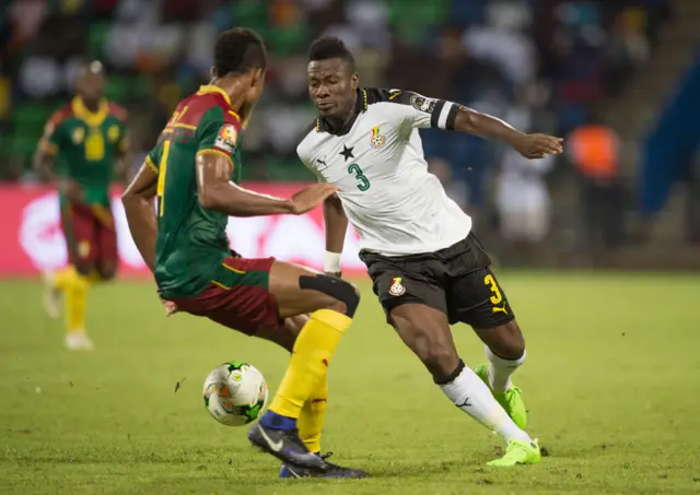 FRANCEVILLE, GABON - FEBRUARY 02: ASAMOAH GYAN of Ghana and ADOLPHE TEIKEU KAMGANG of Cameroon during the Semi Final match between Cameroon and Ghana