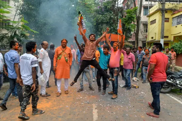 An Indian supporter of Bharatiya Janata Party (BJP) jumps in the air as he celebrates along with others on the vote results day for India's general election in Siliguri.