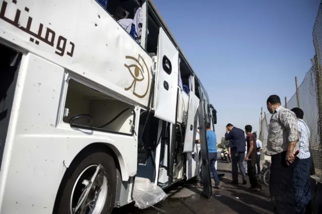 Security officials stand next to a tourists" bus that was targeted by an explosive device near Grand Egyptian Museum in Giza, Egypt, 19 May 2019.