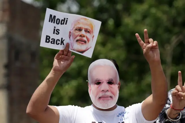 A Bharatiya Janata Party (BJP) supporter wears a mask dipicting Indian Prime Minister Narendra Modi.