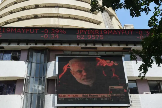 A digital broadcast shows an image of Indian Prime Minister Narendra Modi next to stock prices outside the Bombay Stock Exchange (BSE) in Mumbai on May 23, 2019.