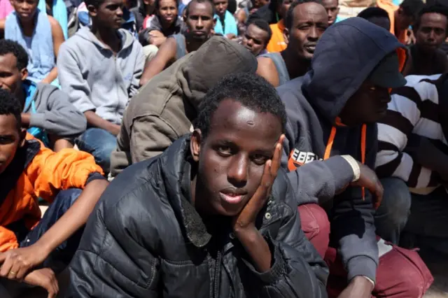 Migrants from sub-Saharan Africa sit at a center for illegal migrants in the al-Karem district of the Libyan eastern port city of Misrata on April 15, 2015, after their boat was intercepted by the Libyan coast guard.