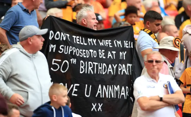 Fan in the stand holds up a banner