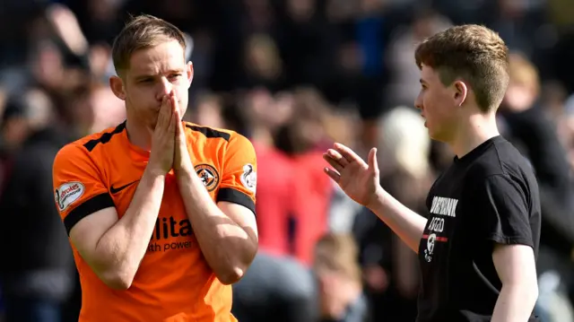 Dundee United's Peter Pawlett is consoled by a fan