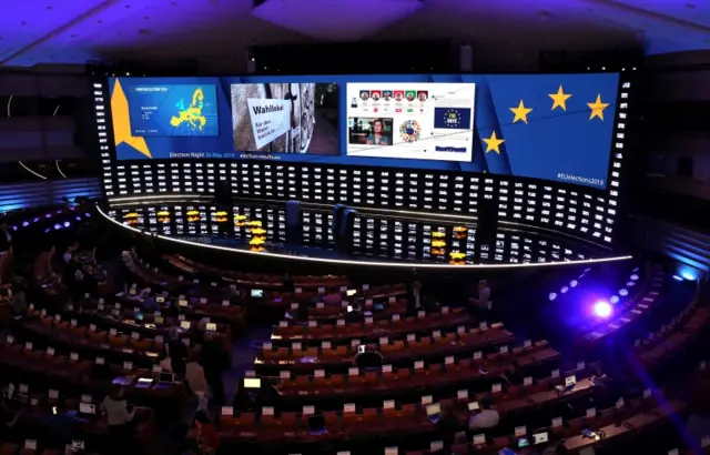 An image shows the stage set up in a hemicycle at the European Parliament in Brussels