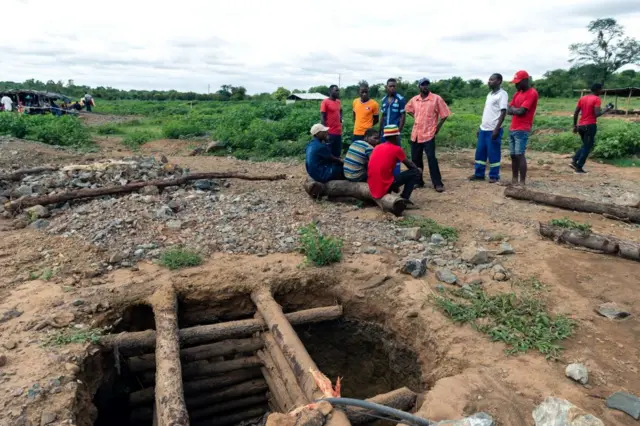 Fellow miners gathered beside a pit during a mine search and rescue operation at Cricket Mine in Kadoma, Mashonaland West Province where more than 23 artisinal miners are trapped underground and feared dead on February 15, 2019.