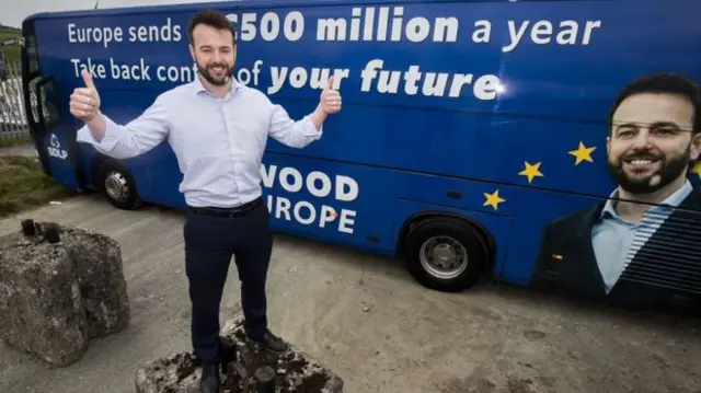 Colum Eastwood poses in front of the 'anti-Brexit battle bus'