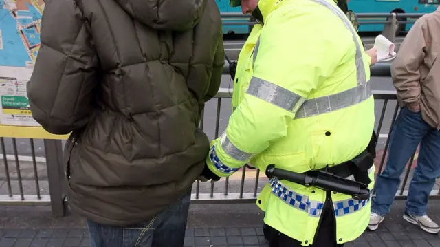 Man being stopped and searched by police officer