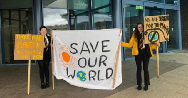 Two school children holding banners