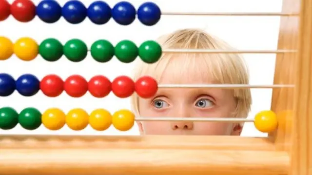 A child in front of an abacus