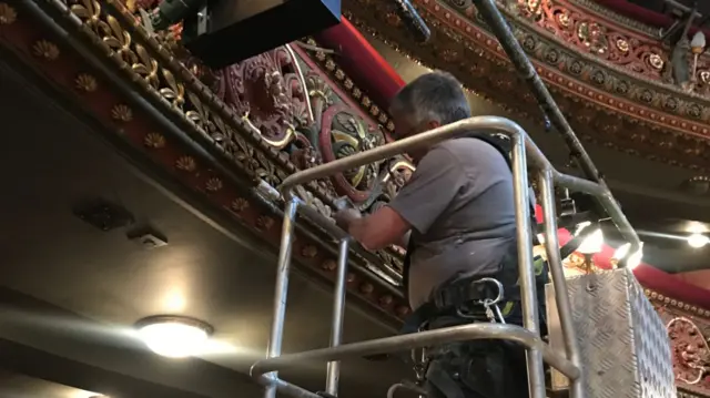 A man taking moulds while standing on a cherry picker