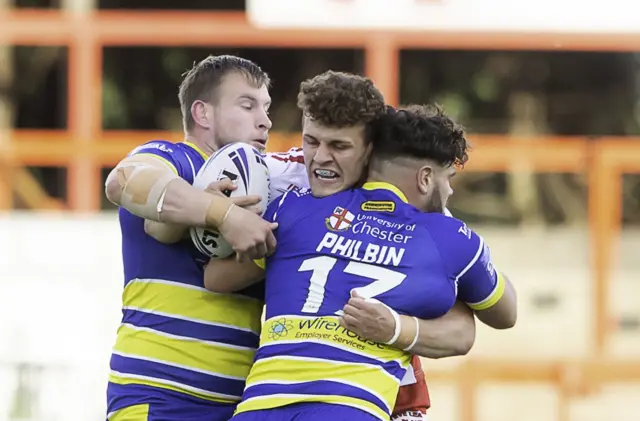 Hull KR's George Lawler is tackled by Warrington's Mike Cooper & Joe Philbin