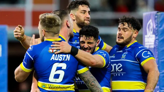 Warrington players celebrate scoring a try against Hull KR