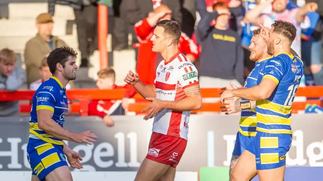 Jake Mamo (left) celebrates scoring a try for Warrington Wolves