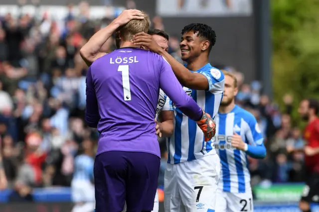 Huddersfield players congratulate Terriers goalkeeper Jonas Lossl for his assist