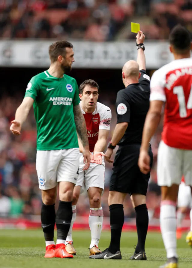 Sokratis Papastathopoulos is shown a yellow card by referee Andrew Taylor