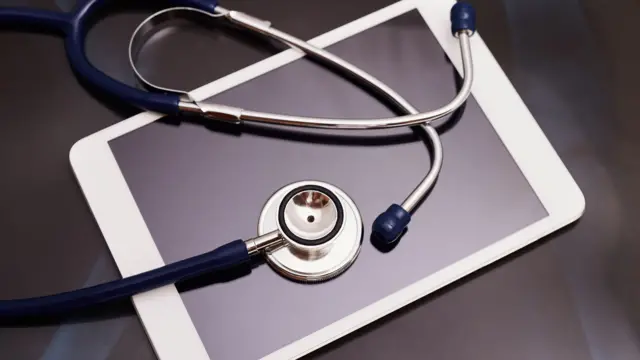 A stethoscope on top of a tablet