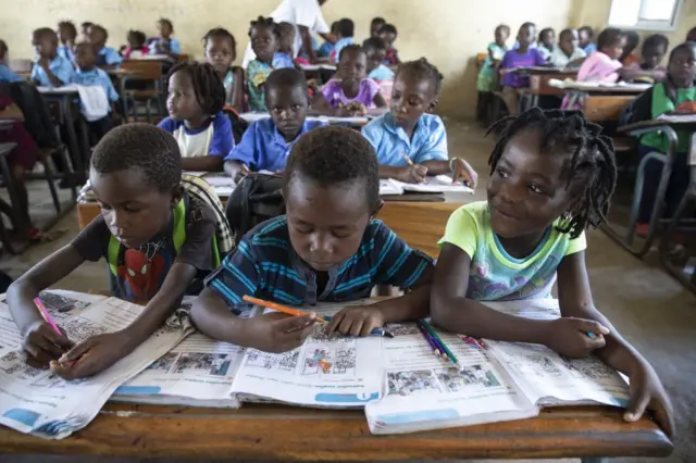 Mozambican children study from textbooks in a classroom