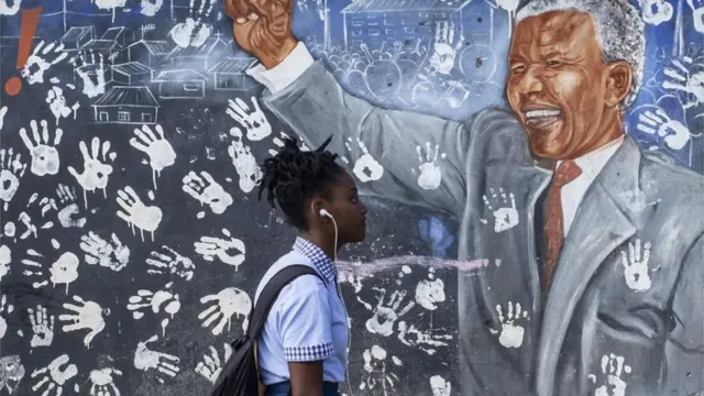 A school girl walks past a mural of Nelson Mandela near a voting station in Alexandra township, Johannesburg, South Africa, 07 May 2019