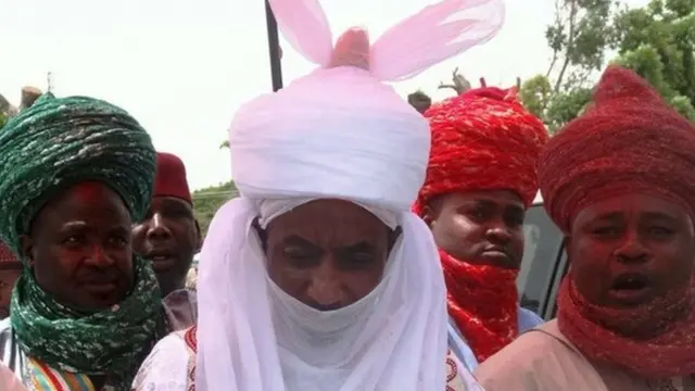 The new emir of the northern Nigerian city of Kano Lamido Sanusi (C) walks in Kano on 9 June 2014