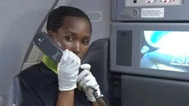 The flight attendant speaks to passengers on board the RwandAir plane