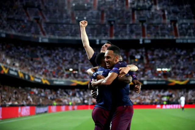 Arsenal players celebrate with view of Mestalla behind