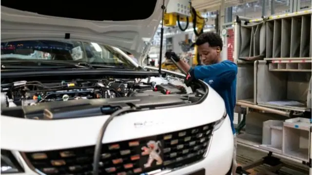 An Eritrean man pictured working on a car in a workshop