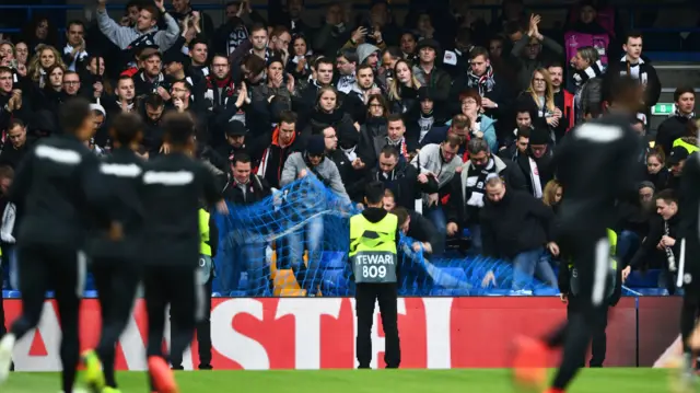 Frankfurt fans rip up nets designed to keep the front three rows of the away end clear at Stamford Bridge