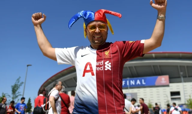 A football fan with a half and half Tottenham and Liverpool shirt