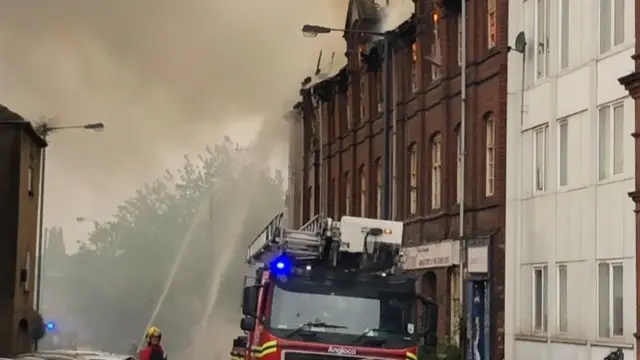 Firefighters spraying water on the fire