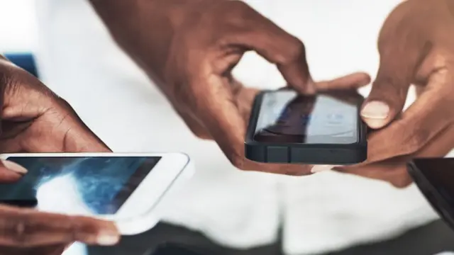 Two people use their smartphones