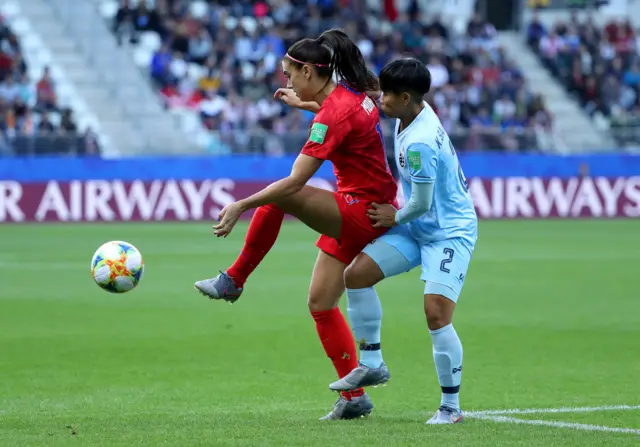 Alex Morgan of the USA is challenged by Kanjanaporn Saenkhun of Thailand