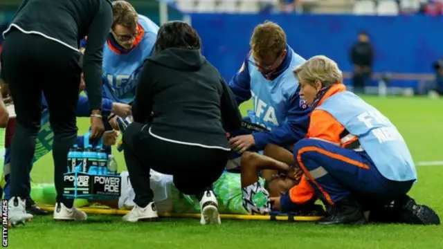 Faith Michael on a stretcher being taken off the pitch