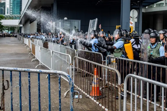 Police officers use pepper spray as protesters occupy outside Legislative Council in Hong Kong on June 12, 2019