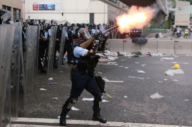 Police officer fires tear gas at protesters during a demonstration against a proposed extradition bill in Hong Kong, China June 12, 2019.