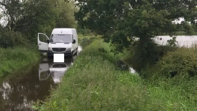 Van on flooded road