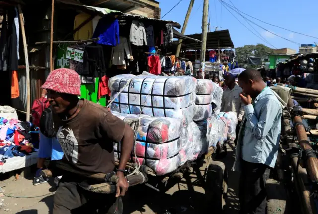 Man pulling a barrow full of clothes