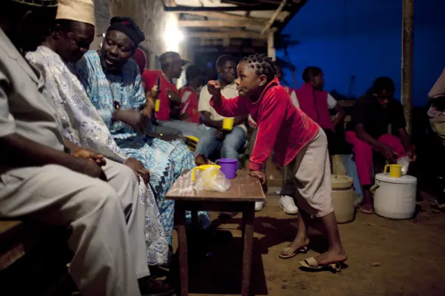 People drinking in the dark outside in Cameroon