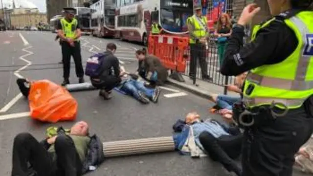 Climate change protestors lay down in the road with their arms chained together on Lothian Road