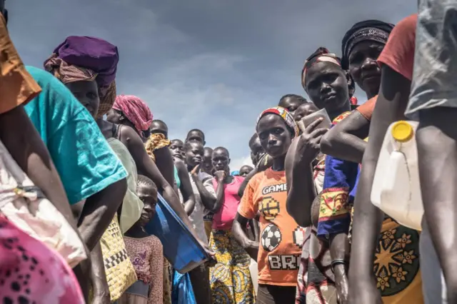 South Sudanese refugees wait to collect their food allowance from the World Food Programme in northern Uganda.