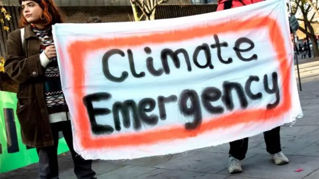 People with a climate emergency banner