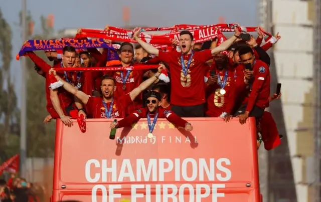 Liverpool players hold flags aloft