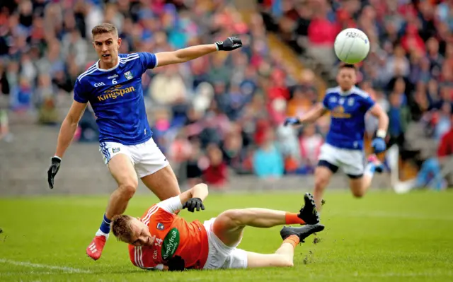 Cavan defender Killian Carke stays on his feet as Armagh's Rian O'Neill takes a tumble