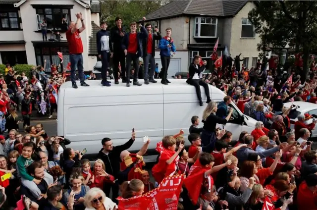 Liverpool fans climb onto cars