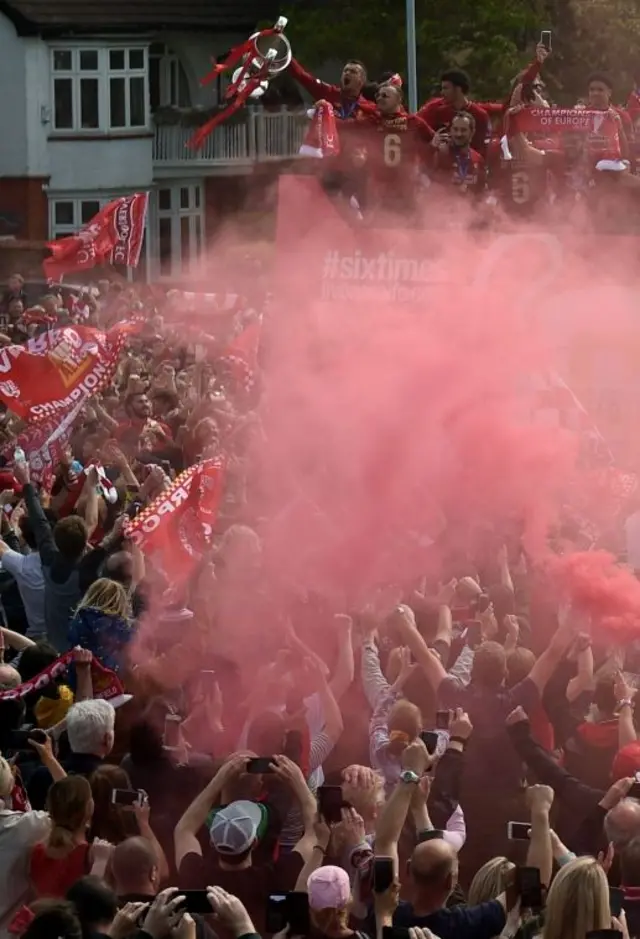 Liverpool defender Dejan Lovren holds the European Champion Club's Cup trophy over crowds