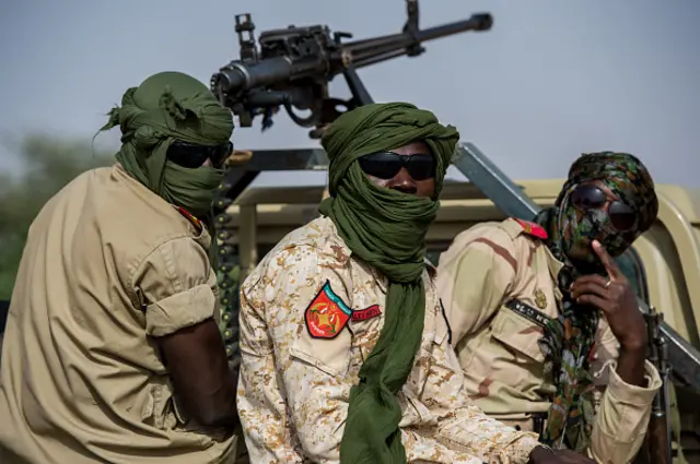 Armed soldiers of the Niger National Guard protect a convoy in the Sahara Desert