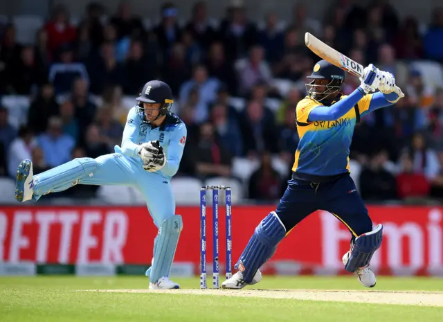 Angelo Matthews of Sri Lanka in action batting as Jos Buttler of Englnd looks on