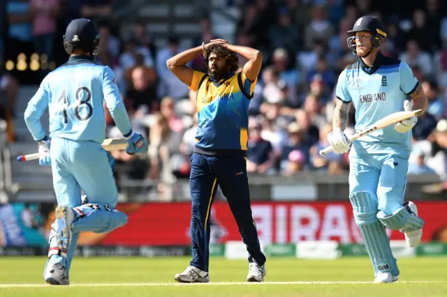 Lasith Malinga (C) reacts as England"s Moeen Ali (L) and England's Ben Stokes add runs